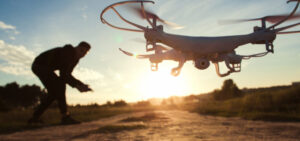 Pilot running drone at sunset light, free space